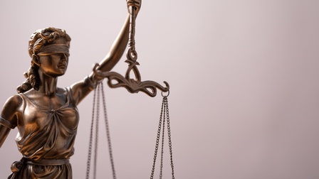 Figur Justitia, die die Waage der Gerechtigkeit in der Hand hält