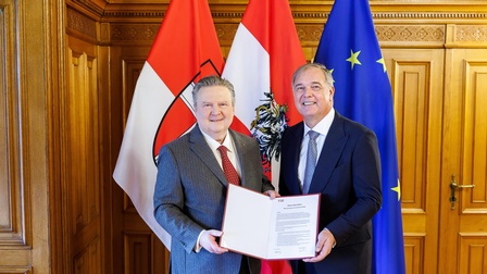 Ludwig und Ruck halten Vertrag - dahinter Wien-, Österreich- und Europa-Flagge 