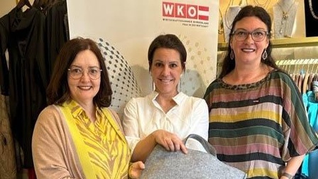 Drei Frauen halten eine Tasche