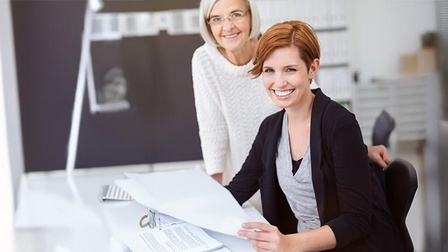 Ältere Frau mit jüngerer Frau in einem Büro.