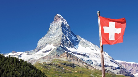 Blick auf das Matterhorn mit einer Schweizer Flagge im Vordergrund.