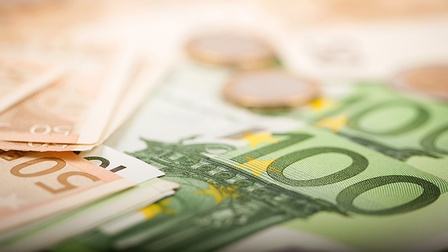 Detailansicht von 100- und 50-Euro-Gelscheinen, zwei Euromünzen verschwommen