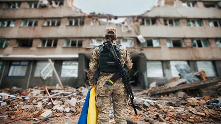Soldatin vor zerstörtem Gebäude