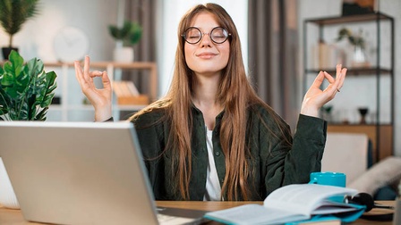 Frau sitzt hinterm Laptop