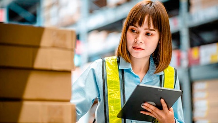 Frau im Lager begutachtet Paket