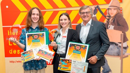 Handelsobmann Gerhard Wohlmuth (r.) mit Leon Heiling (l.) und Kim Sophie Kuntner bei der Auszeichnung