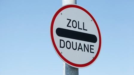 Weißes Schild mit rotem Rand und Aufschrift Zoll sowie Douane