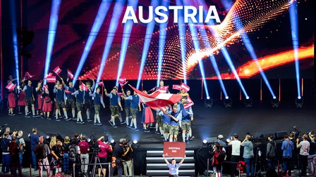 Teilnehmer:innen aus Österreich auf Bühne im Saal