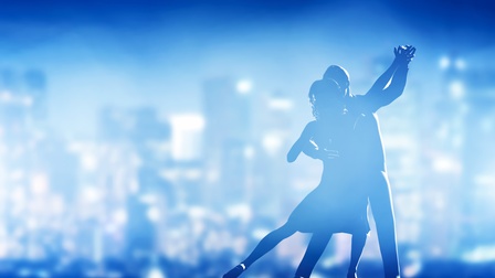 Vektor-Illustration in Blautönen. In der rechten Bildhälfte ist die Silhouette zweier tanzender Personen. Die Personen halten sich an den Händen und haben die Arme jeweils auf dem Rücken der anderen Person abgelegt. Im Hintergrund sind Wolkenkratzer. 