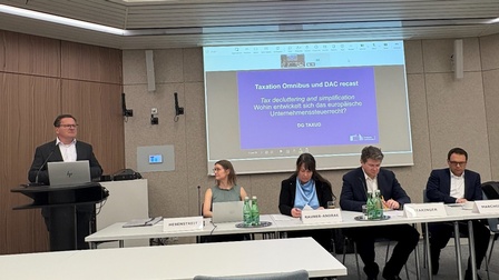 Teilnehmer:innen am Podium, einer präsentiert