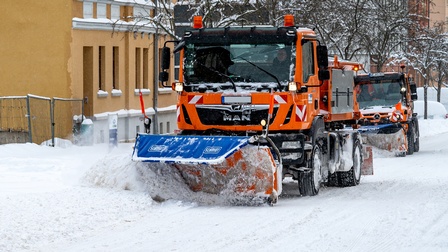 Zwei Fahrzeuge mit Schneepflug führen Schneeräumarbeiten durch, Winterdienst