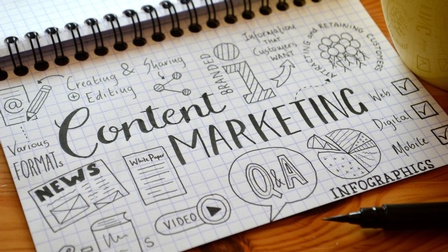 Karierter Notizblock mit Scribbles zu Content Marketing