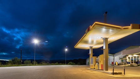 Eine leere, beleuchtete Tankstelle bei Nacht