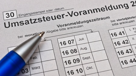Detailansicht eines Dokuments mit Schriftzug Umsatzsteuer-Voranmeldung und Stiftspitze