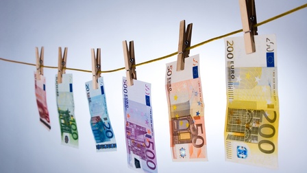 Verschiedene Euro-Scheine auf Wäscheleine mit Kluppen befestigt hängend