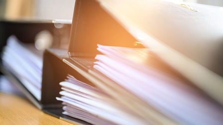 Nahaufnahme dreier Ordner mit Unterlagen