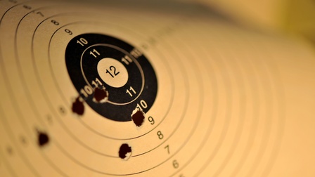 Man sieht eine Zielscheibe mit Löchern, die von oben fotografiert ist.