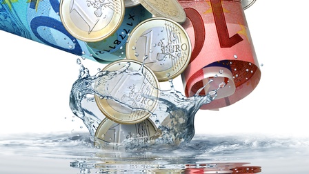 Euroscheine in Rollen und Münzen beim Eintauchen in Flüssigkeit