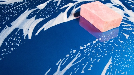 Rosa Schwamm und weißer Schaum auf einem blauen Untergrund