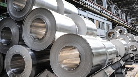 Einige Aluminiumrollen liegen übereinander gestapelt in einem Lagerhaus