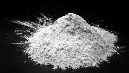 Nahaufnahme eines kleinen Haufens weißen Pulvers auf einem dunklem Untergrund