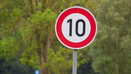 Schild mit Geschwindigkeitsbeschränkung 10, im Hintergrund zeigt