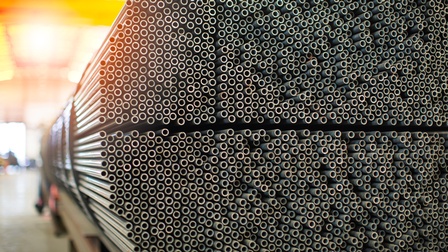 Nahaufnahme sehr vieler, dicht übereinander gestapelter Metallrohre. Der Durchmesser der Rohre ist nicht groß