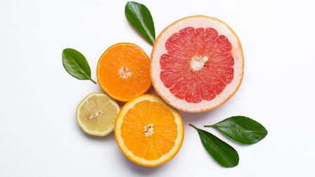 Aufgeschnittene Zitrusfrüchte in Scheiben mit Minzeblätter arrangiert