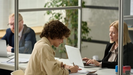 Junge Frau füllt Formulare in einer Behörde aus