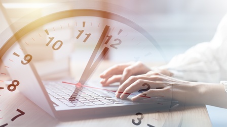 Person tippt in einem Laptop, darüber ist eine Uhr mit Zeiger kurz vor 12 visualisiert.