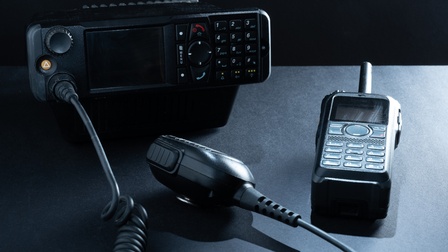 Nahaufnahme einer schwarzen Funkstation und eines schwarzen Funkgeräts auf schwarzem Hintergrund