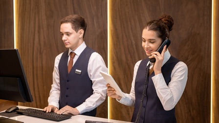 Ein junges Paar Hotelkaufmann/-frau arbeiten an der Hotelrezeption