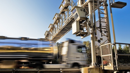 LKW in Bewegungsunschärfe beim Passieren einer Mautregistratur