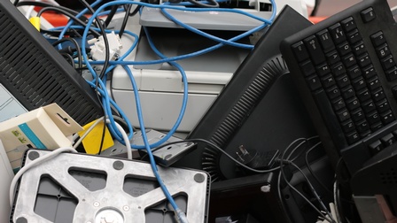 Detailansicht Elektroschrott: Haufen mit Tastaturen, Kabeln, Drucker und Monitoren