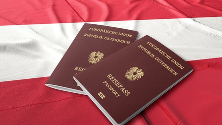 Zwei Reisepässe der Republik Österreich sind auf einer rot-weiß-roten Fahne platziert