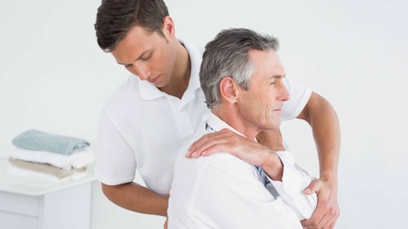 Ein älterer Mann wird chiropraktisch behandelt