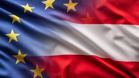 Überlappung der EU- und Österreich-Flagge: Blauer Stoff in Falten mit gelben in Kreisform angelegten Sternen verlaufen in rot-weiß-rot gestreiften Stoff