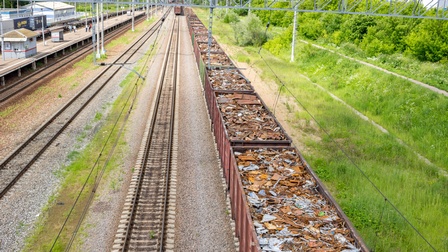 Blick von oben auf eine Schienentransportstrecke mit Güterwägen voll Metallabfällen
