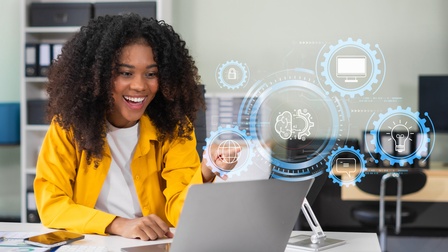 Eine Person mit lockigem, dunklem Haar sitzt an einem Schreibtisch. Vor der Person ist ein aufgeklappter Laptop, auf dessen Bildschirm sie blickt. Auf dem Bild sind verschiedene Symbole wie eine Glühbirne, ein Zahnrad, in dem AI steht etc