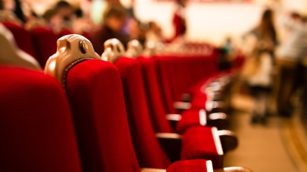 Nahaufnahme auf rote, leere Sitze im Theater.