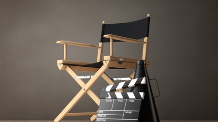 3D-Rendering eines Regiestuhls, an dem eine Filmklappe angelehnt ist vor einer dunklen Wand.