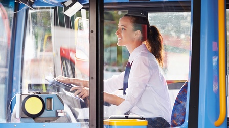 Lächelnde Person steuert einen Bus