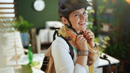 Lächelnde Person beim Betätigten des Verschlusses eines Fahrradhelms