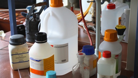 Verschiedene Plastikflaschen mit Chemikalien auf Tisch