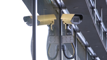 Überwachungskamera, die bei einem Gebäude montiert ist