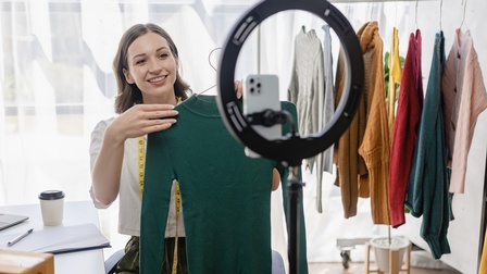 Bloggerin zeigt Pullover in Kamera