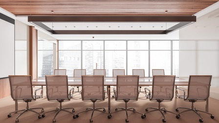 In einem großen Raum mit Fensterfront steht ein großer Tisch mit zwölf Stühlen für Besprechungen oder sonstige größere Zusammenkünfte