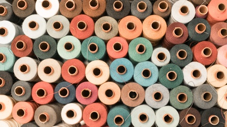 Detailansicht nebeneinanderliegender Zwirne in verschiedenen Farben