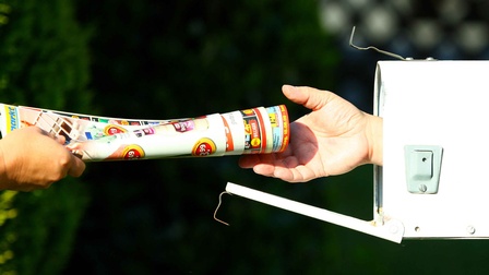 Eine Hand reicht einer anderen Hand ein Bündel an Prospekten