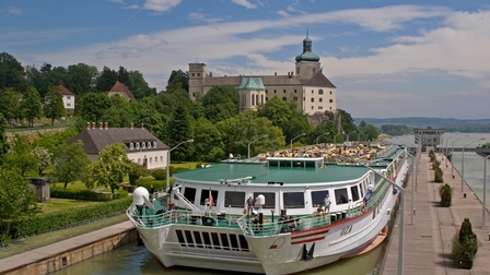 Schiff in Schleuse, im Hintergrund Schlossgebäude